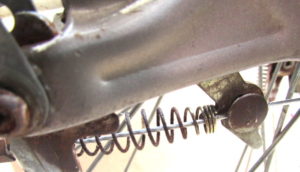 スプリングの中と、ブレーキ固定ネジ穴に通ってます。